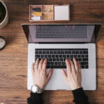 womans-hands-working-on-laptop-at-home-office-top-view-MOMF00639